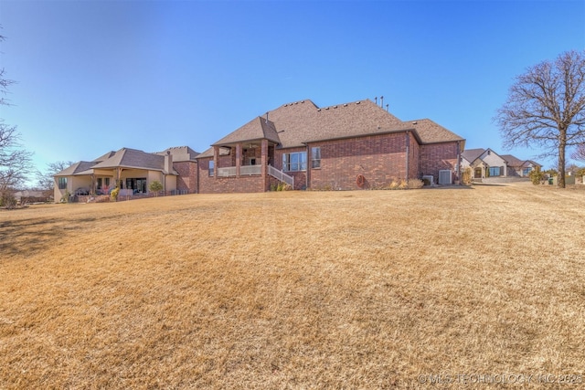 exterior space featuring brick siding and a front yard