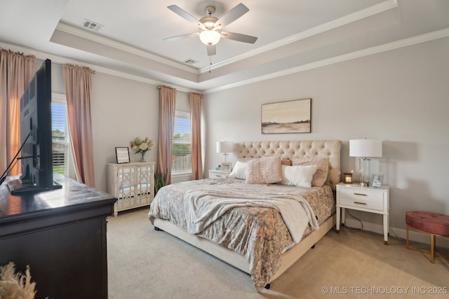 bedroom with visible vents, light colored carpet, crown molding, and a tray ceiling