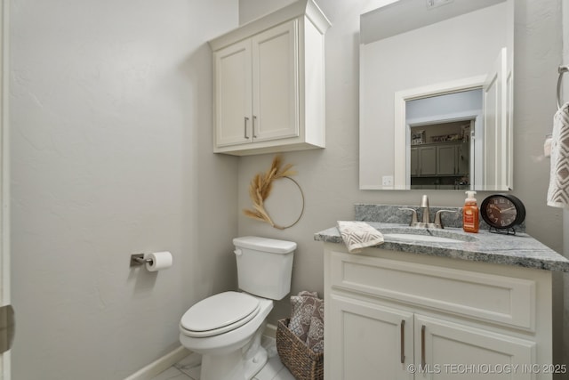 half bath featuring vanity, toilet, and baseboards