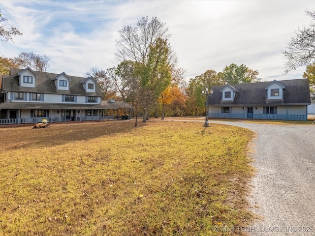 view of front facade with a front yard, covered porch, and driveway