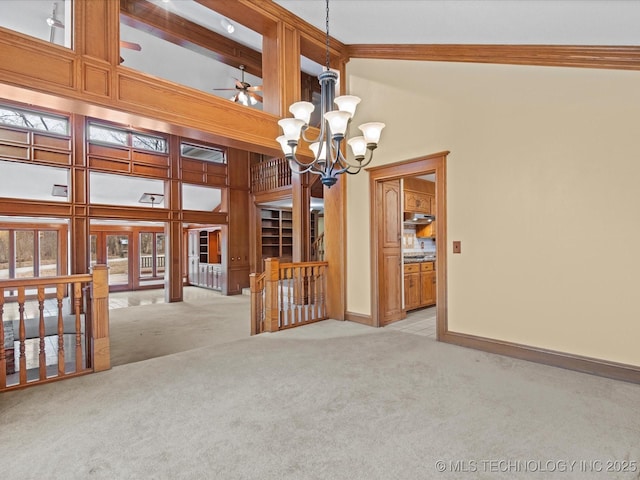 empty room with beam ceiling, high vaulted ceiling, an inviting chandelier, baseboards, and light colored carpet