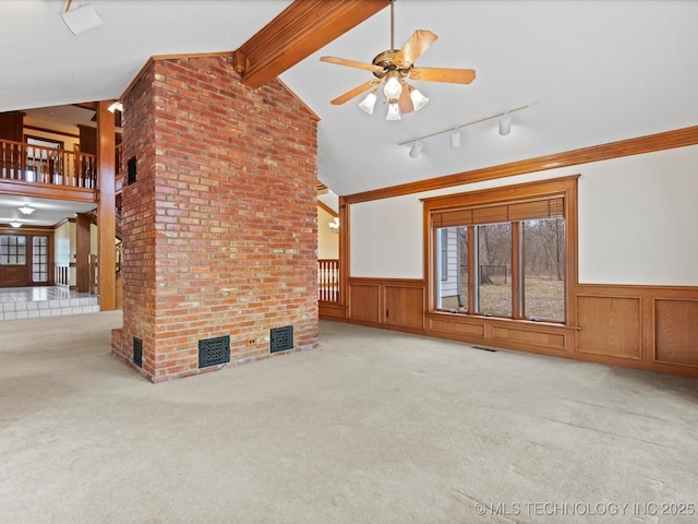 unfurnished living room featuring visible vents, carpet floors, and wainscoting