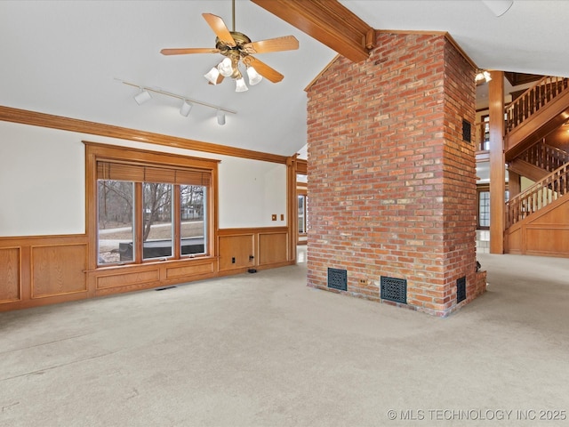 unfurnished living room with lofted ceiling with beams, a wainscoted wall, carpet floors, and visible vents