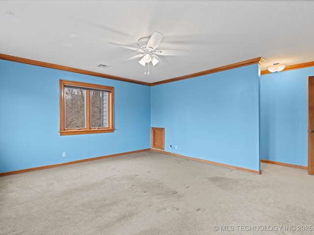 unfurnished room with visible vents, carpet flooring, crown molding, and baseboards