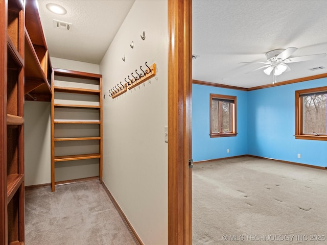 walk in closet featuring a ceiling fan, carpet, and visible vents