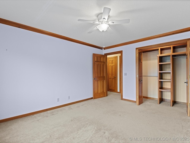 unfurnished bedroom featuring light carpet, ornamental molding, a ceiling fan, a closet, and baseboards