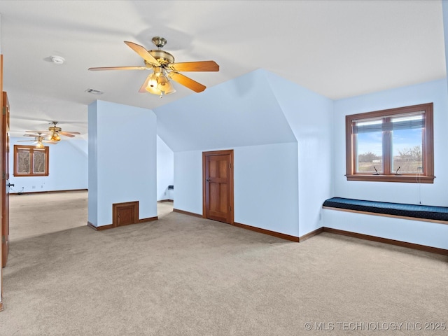 additional living space featuring visible vents, ceiling fan, baseboards, vaulted ceiling, and carpet floors