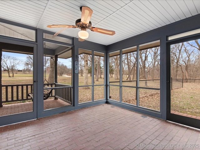 unfurnished sunroom with ceiling fan