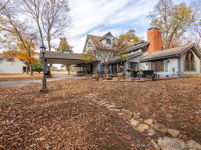 exterior space with a carport and a chimney