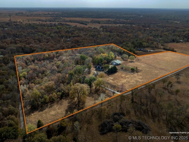 drone / aerial view featuring a view of trees and a rural view