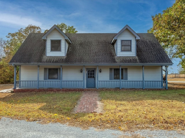 view of front facade with a porch, a front lawn, and roof with shingles