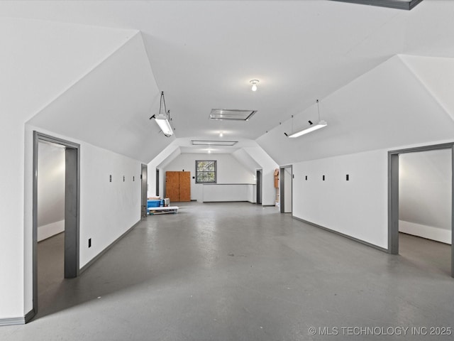 additional living space with lofted ceiling and finished concrete floors