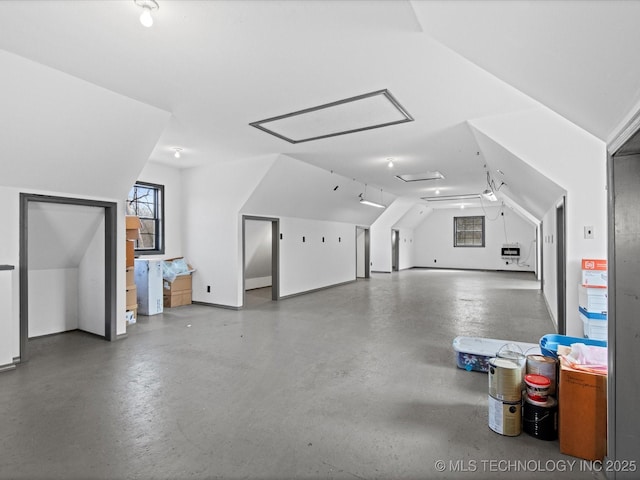 additional living space with vaulted ceiling and concrete flooring