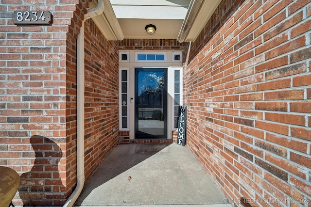 property entrance featuring brick siding