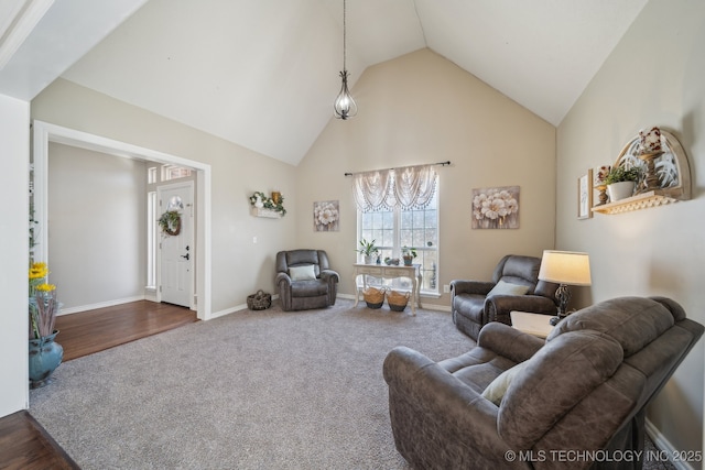 living area featuring baseboards, high vaulted ceiling, and carpet