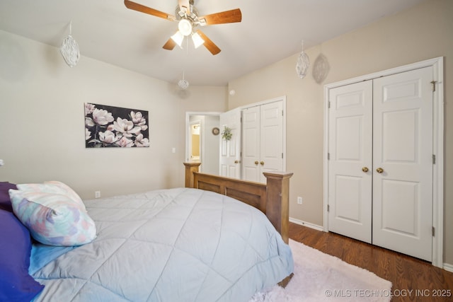 bedroom with baseboards, a ceiling fan, multiple closets, and wood finished floors