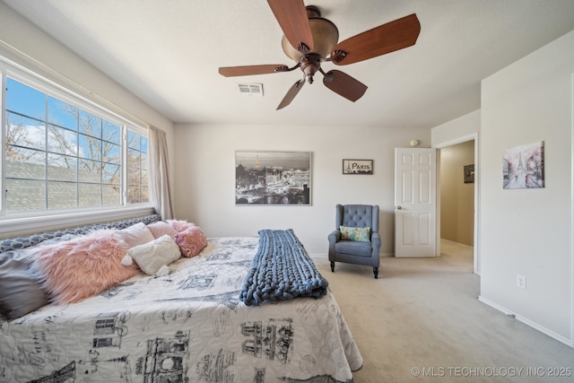 carpeted bedroom with visible vents, a ceiling fan, and baseboards