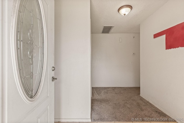 interior space featuring visible vents, carpet, and a textured ceiling