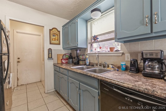 kitchen with light tile patterned floors, a sink, decorative backsplash, black dishwasher, and dark countertops