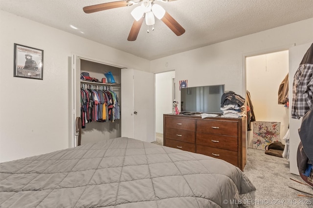 carpeted bedroom with a closet, a textured ceiling, and a ceiling fan