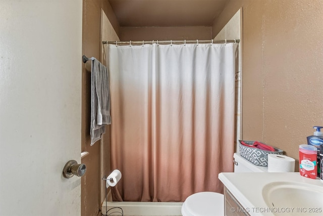 bathroom featuring vanity, curtained shower, and toilet