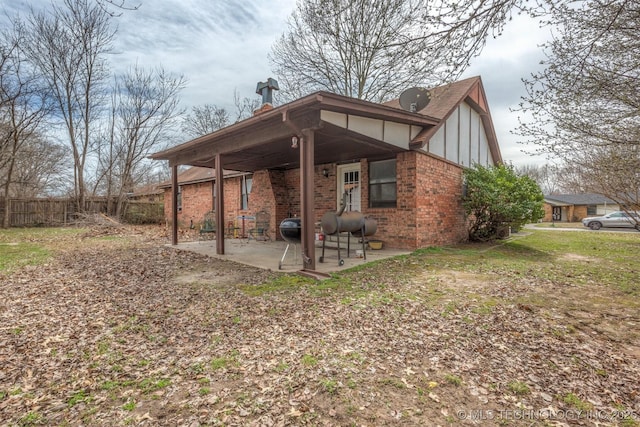 back of house featuring a patio, fence, and brick siding