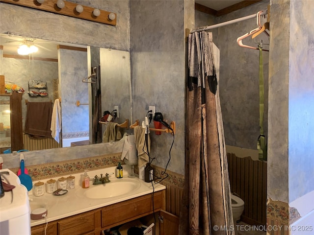 bathroom featuring toilet, vanity, and a shower with curtain