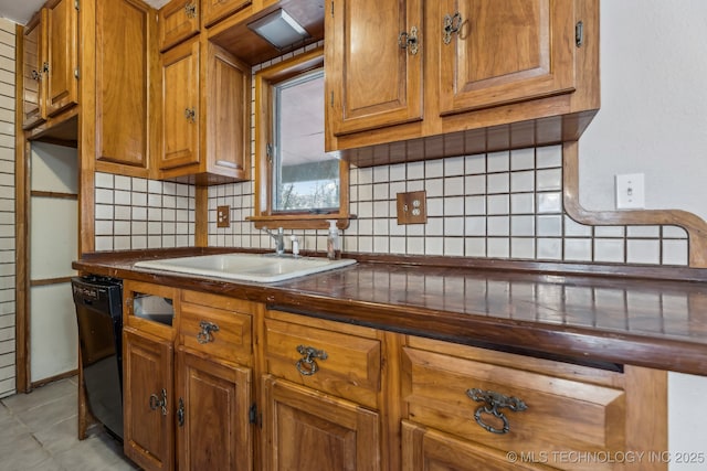 kitchen featuring a sink, backsplash, black dishwasher, and dark countertops