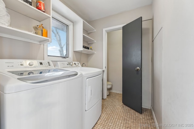 laundry area featuring washer and dryer, laundry area, light tile patterned floors, and baseboards