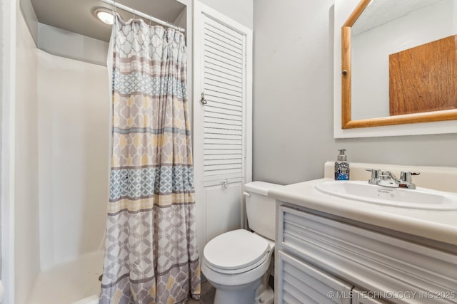 bathroom with vanity, a shower with shower curtain, and toilet