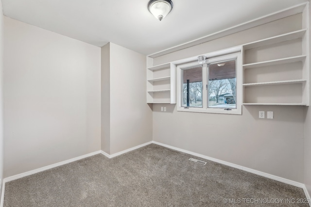 carpeted spare room with baseboards and visible vents