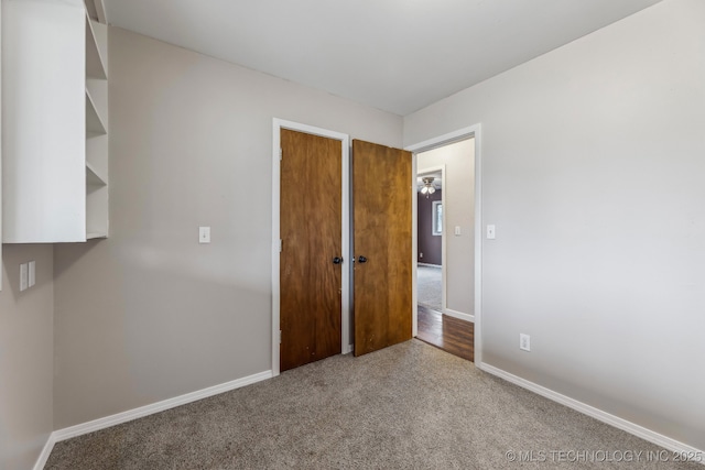 carpeted spare room featuring baseboards