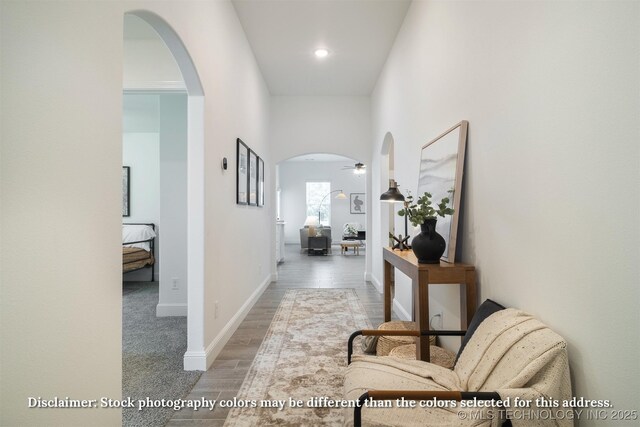 hall with recessed lighting, arched walkways, baseboards, and wood finished floors