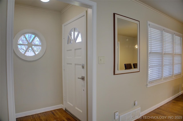 entryway with ornamental molding, baseboards, and wood finished floors