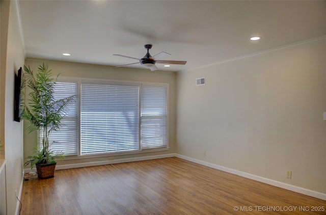 unfurnished room with ceiling fan, visible vents, baseboards, and wood finished floors