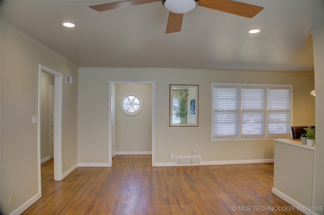 foyer with visible vents, baseboards, wood finished floors, and crown molding