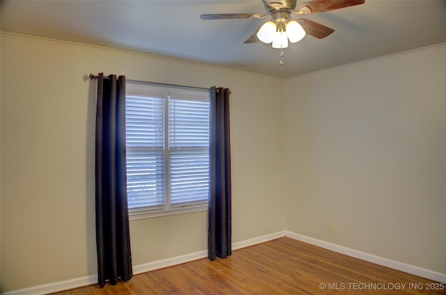 empty room featuring a ceiling fan, baseboards, and wood finished floors