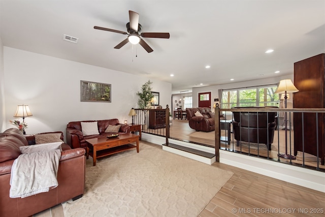 living room with visible vents, recessed lighting, a ceiling fan, and light wood-style floors