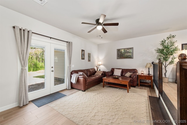 living room featuring french doors, light wood-style flooring, ceiling fan, and baseboards
