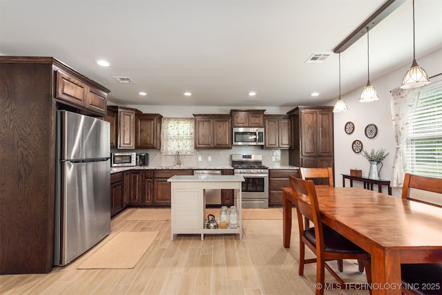 kitchen featuring stainless steel appliances, visible vents, and dark brown cabinets