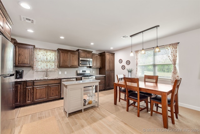 kitchen with tasteful backsplash, appliances with stainless steel finishes, a sink, and visible vents