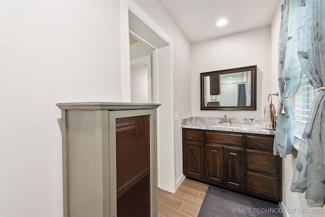 bathroom featuring wood finish floors, recessed lighting, and vanity