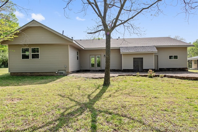 rear view of house with a patio, french doors, roof with shingles, and a lawn