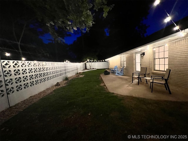 yard at twilight featuring a patio and a fenced backyard