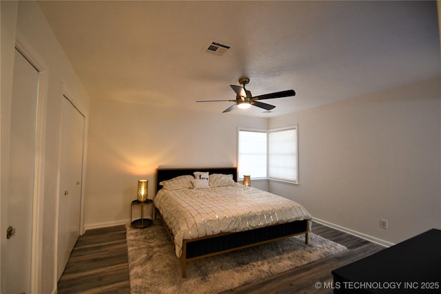 bedroom with visible vents, baseboards, dark wood-style floors, and a ceiling fan