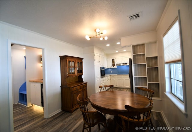 dining area with visible vents, baseboards, a notable chandelier, and dark wood-style floors