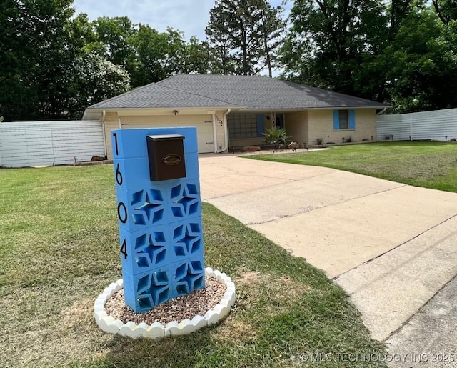 single story home with brick siding, a front lawn, fence, concrete driveway, and an attached garage