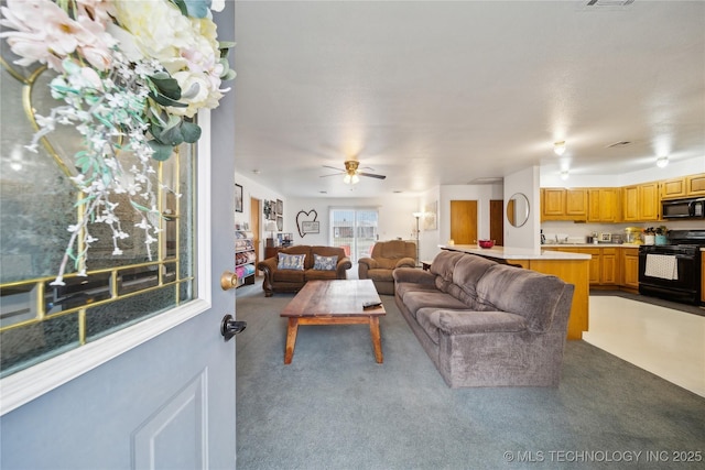 carpeted living room with visible vents and ceiling fan