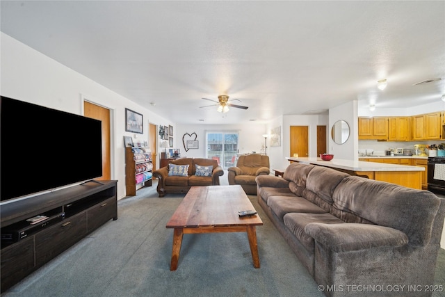 living room featuring light carpet, visible vents, and a ceiling fan