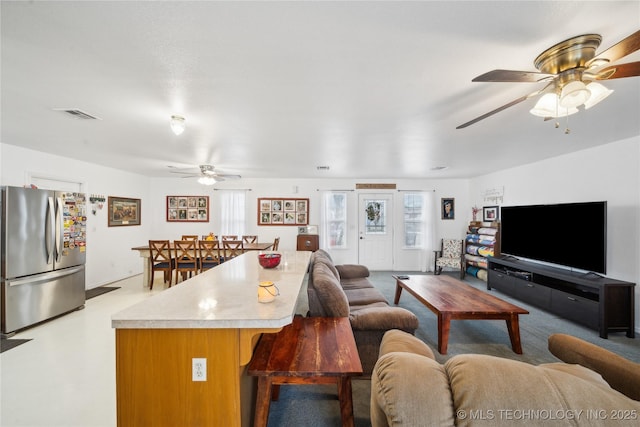 living area featuring visible vents and a ceiling fan